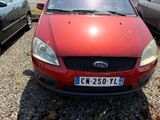 a red car parked in a parking lot with other cars
