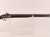 gros plan d'un fusil posé sur un support sur une surface blanche
