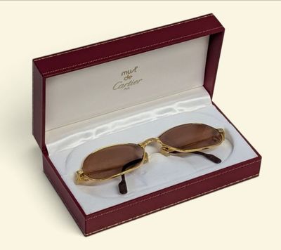 pair of brown sunglasses in a red box on a white surface