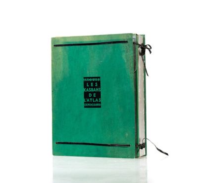 un vieux livre à la couverture verte posé sur une surface blanche