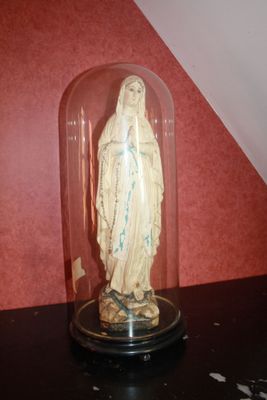 a statue of a woman under a glass dome on a table