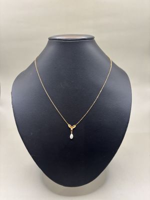 un collier en or orné d'une perle autour du cou d'un mannequin