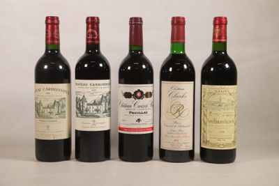 quatre bouteilles de vin rouge sont alignées sur une table