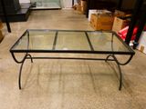 une table basse en verre avec une structure en métal et un plateau en verre