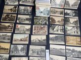 un grand nombre de cartes postales anciennes qui se trouvent sur la table