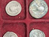 an assortment of roman coins in a red case