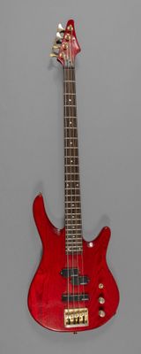 une image représentant une guitare basse électrique rouge sur fond gris