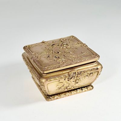 a gold box that is sitting on a white surface