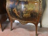 a small table with a painting on it next to a mirror