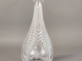 clear glass perfume bottle with a bird on the top of it