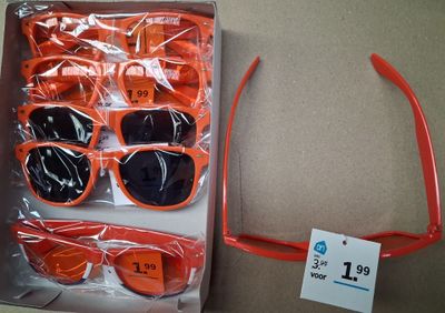 plusieurs paires de lunettes de soleil dans une boîte avec une étiquette de prix