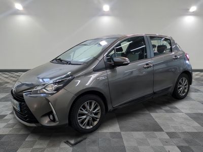 une Toyota Yaris grise garée sur un sol en carrelage à damier