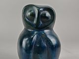 figurine de chouette en céramique bleue posée sur une surface blanche
