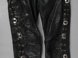 un gros plan d'un pantalon en cuir noir sur fond blanc