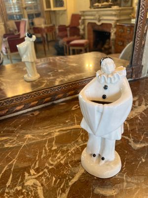 une petite figurine blanche posée sur une table en marbre