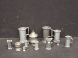de nombreuses tasses et mugs en argent posés sur une table