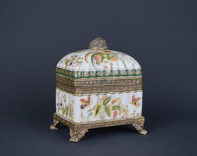 a white and gold box with flowers and birds on it