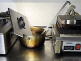 two deep fryers sitting on a stainless steel counter top