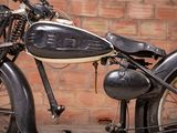 a black motorcycle parked in front of a brick wall