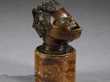 un buste en bronze représentant une femme coiffée d'une couronne, posé sur un socle en bois