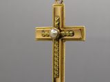 un pendentif en forme de croix en or avec une perle au centre