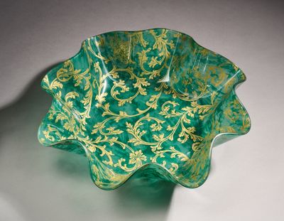 a green glass bowl with gold designs on it