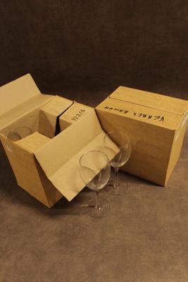 deux verres à vin vides dans une boîte en carton posée par terre