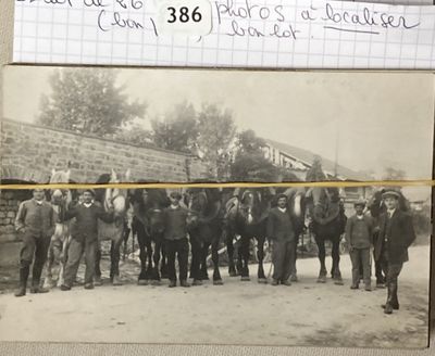 une vieille photo montrant un groupe d'hommes debout à côté d'un cheval