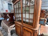 un vaisselier en bois avec des portes vitrées, placé au milieu d'une pièce