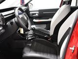the interior of a red car with black leather seats and a steering wheel