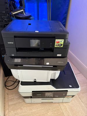 a stack of printers sitting on top of each other on the floor