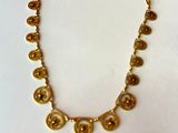 un collier orné de pièces d'or posé sur une table en bois