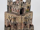 une petite maquette de château posée sur une surface blanche