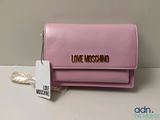un sac à main Moschino rose avec une étiquette dessus