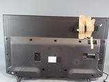someone is removing the back panel of a television that is sitting on the floor