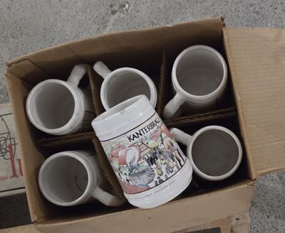 une boîte remplie de tasses à café posée par terre