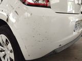 a white car that has been damaged and is parked in a garage