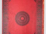 a red book with a black border and a circular design on it