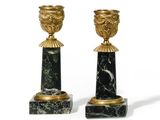 pair of black and gold candlesticks on marble bases