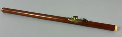 a wooden pipe with a brass handle on a table