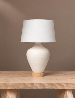 une photo d'une lampe de table blanche posée sur une table en bois