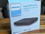 emballage d'un lecteur DVD posé sur une table en bois dans une pièce