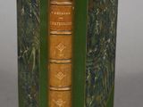 an old book with a green cover sitting on top of a table
