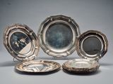 trois assiettes en métal argenté et une assiette en métal argenté sur laquelle est représenté un homme