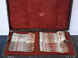 silverware in a case on a table with a black table cloth