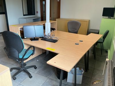 a desk with two computers and a chair in a room