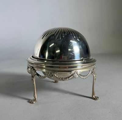 un plat ancien en argent avec un couvercle bombé, posé sur un socle
