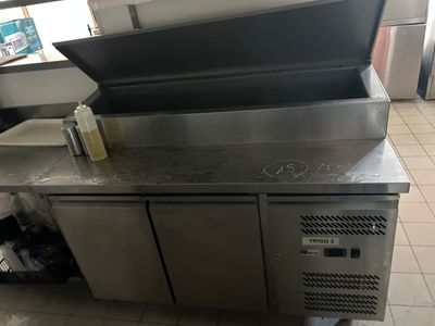 a stainless steel counter top with a bottle of liquid on top of it