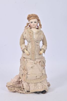 an antique doll of a woman in a dress and hat