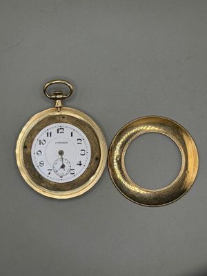 une montre de poche en or et une bague en or posées sur une table